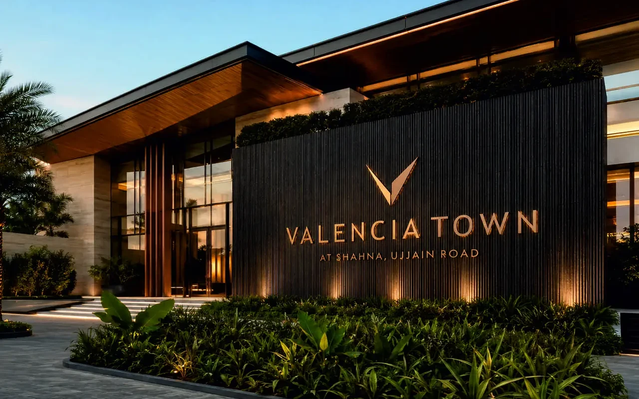 Valencia Town sales gallery at dusk with its illuminated signage wall, artist’s impression